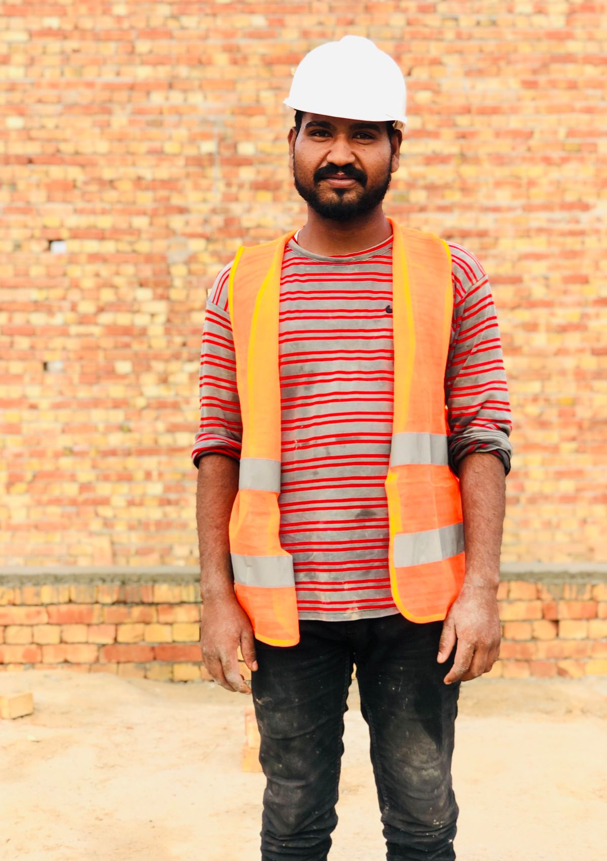 Indian construction worker in a safety helmet and high-vis vest